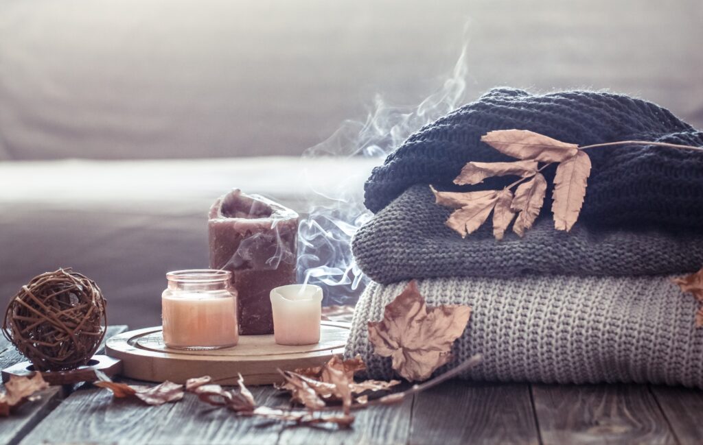 Cozy autumn still life with candles and a sweater